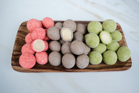 Photo of a tray of strawberry, espresso, and matcha macadamia nuts
