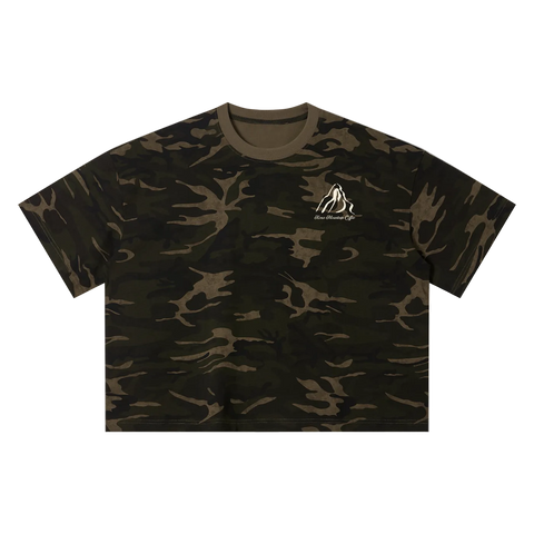 A short-sleeve crewneck t-shirt in a dark green and brown camouflage pattern, featuring a small white mountain logo on the left chest with the text Kona Mountain Coffee